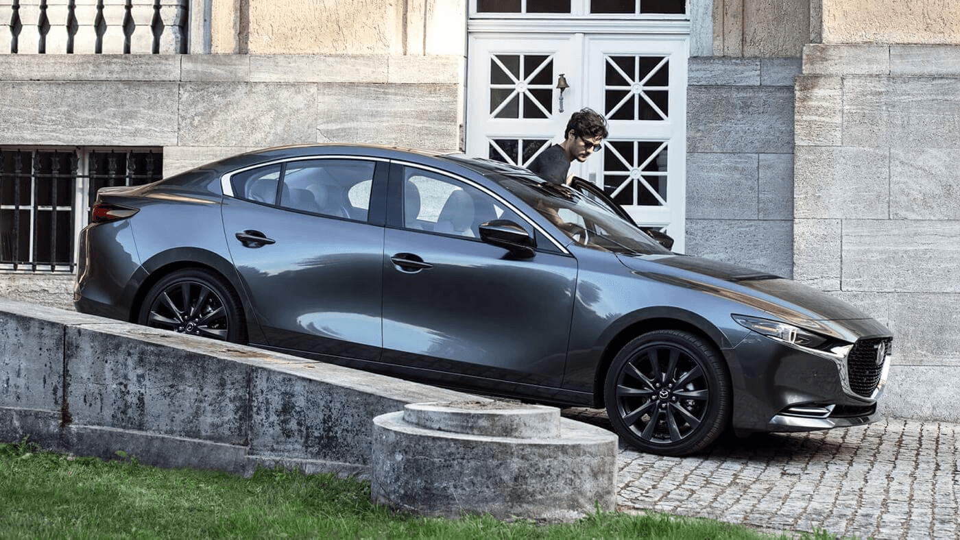 La Mazda 3 stationné devant un bâtiment prête à partir.