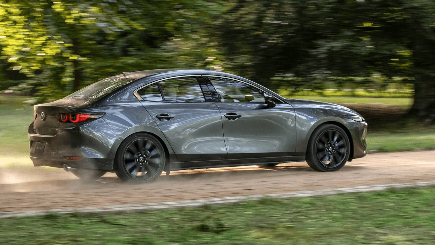 La Mazda 3 qui roule sur un chemin de gravel.