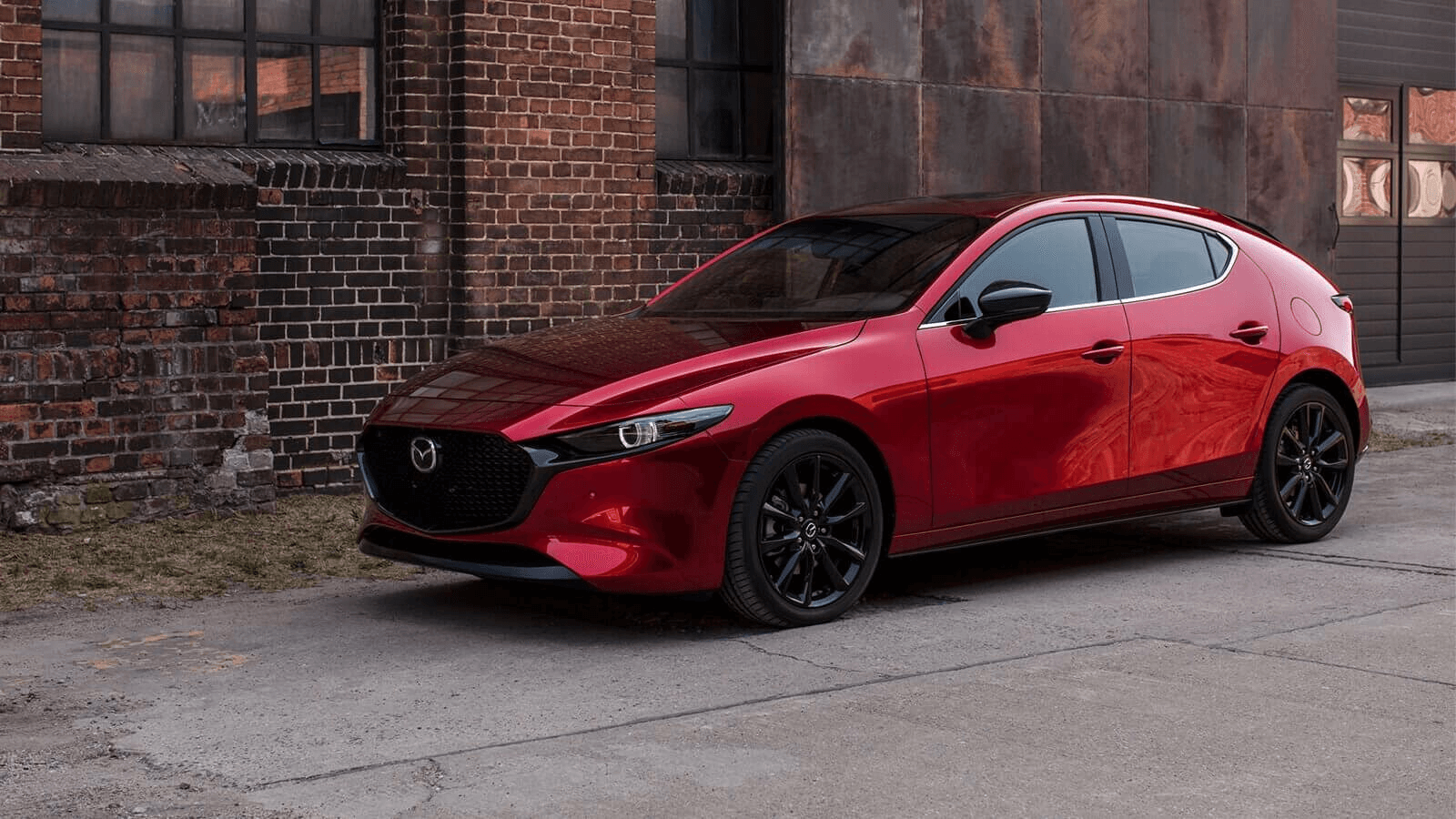 La Mazda 3 sport stationnée devant un bâtiment en ville.